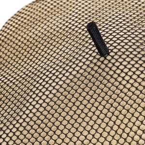 May include: A close-up of a beige mesh fabric with a black strap. The fabric has a grid pattern.