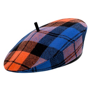 Puede incluir: Un gorro de lana azul, naranja y negro con un pompón negro en la parte superior.