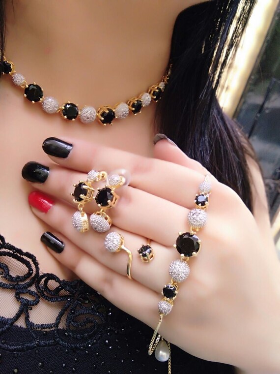 Beautiful girl with set jewelry . Woman in a necklace with a ring