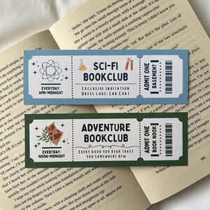 May include: Two colourful bookmarks with a whimsical design. The top bookmark is blue with a beaker and stars and says "Sci-Fi Bookclub" with the text "Exclusive Invitation Dress Code: Lab Coat". The bottom bookmark is green with a pizza slice and stars and says "Adventure Bookclub" with the text "Every book you read takes you somewhere new".