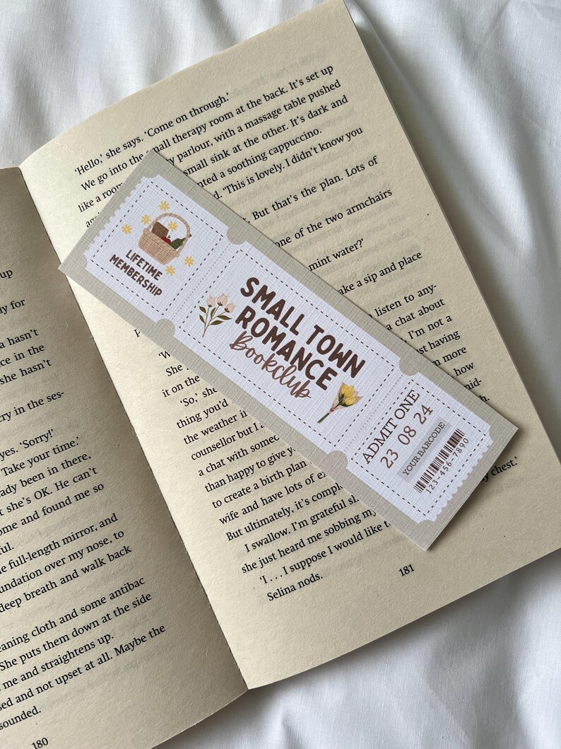 May include: A bookmark with a vintage ticket design featuring a floral illustration and the text "Small Town Romance Bookclub". The bookmark also includes a ticket with the text "Admit One 23 08 24" and a barcode.