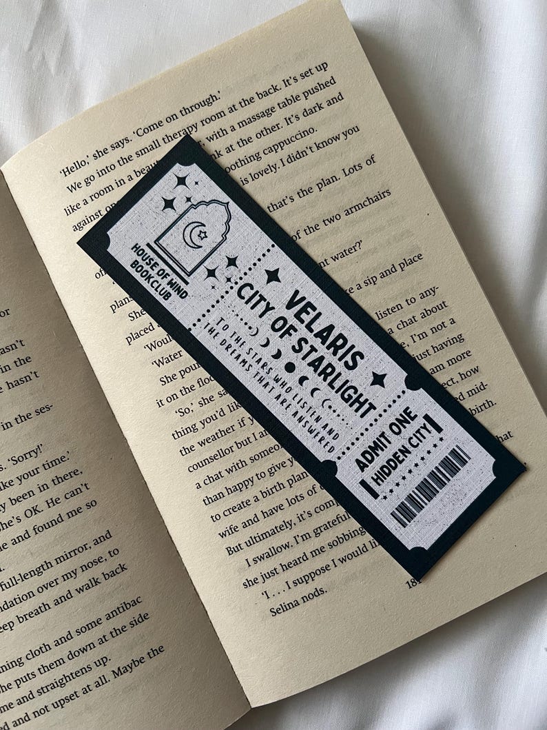 May include: Black bookmark with white text and stars. The bookmark features the text "House of Wind Bookclub", "Velaris City of Starlight", "To the stars who listen and the dreams that are answered", and "Admit One Hidden City".