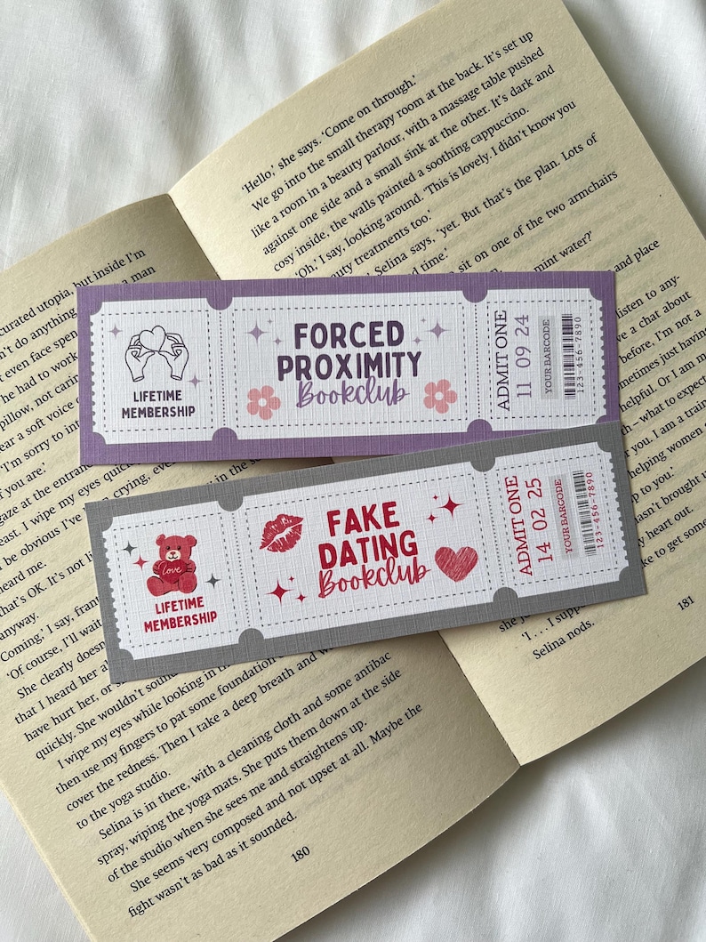 May include: Two colorful bookmarks with a ticket design. The top bookmark is purple and says "Forced Proximity Bookclub" with a pink flower on each side. The bottom bookmark is gray and says "Fake Dating Bookclub" with a red heart on each side. Both bookmarks have a red star on each side.