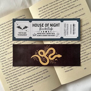 May include: Two black and gold bookmarks with a gothic and spooky theme. The bookmarks feature a bat, a snake, and a crescent moon. The text on the bookmarks reads "House of Night Bookclub" and "Never Trust, Never Yield, Always Guard Your Heart".