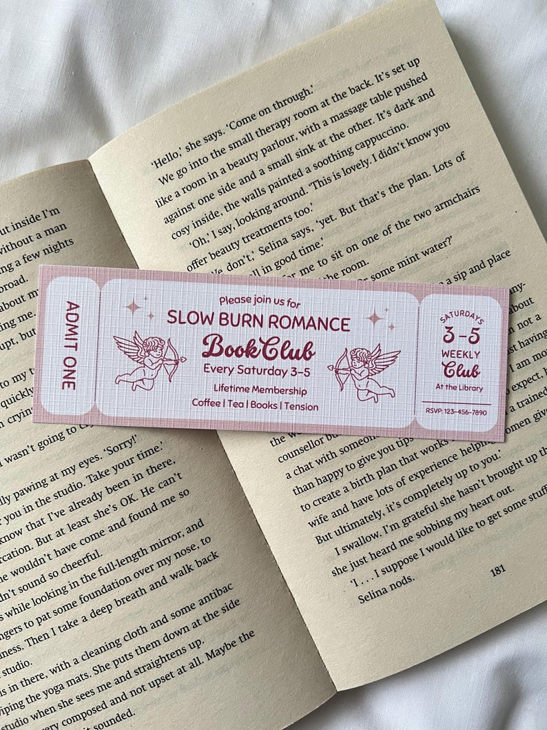 May include: A pink and white ticket with the text "Slow Burn Romance Book Club" in red. The ticket has a graphic of two cherubs with arrows. The text "Every Saturday 3-5" is below the title. The text "Lifetime Membership" is below that. The text "Coffee | Tea | Books | Tension" is below that. The ticket is for a book club.