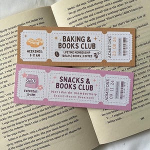 May include: Two pink and brown bookmark tickets with text that reads "Baking & Books Club" and "Snacks & Books Club". The tickets have a vintage look and include the words "Lifetime Membership" and "Worldwide Membership".