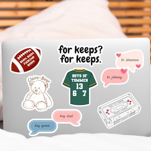 May include: A laptop computer with various stickers, including a football, a teddy bear, a jersey, a cassette tape, and speech bubbles with text that says "for keeps? for keeps", "hi shannon", "hi johnny", "hey queen", and "hey stud".