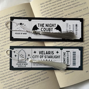 May include: Two black and white bookmark designs with silver tassels. The first bookmark features a bat with the text "The Night Court". The second bookmark features a moon and stars with the text "Velaris City of Starlight".