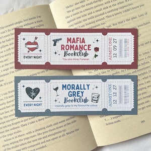May include: Two book club bookmark designs. The first bookmark is red with a gun, heart, and arrow. The text reads "Mafia Romance Bookclub, You are mine. Forever." The second bookmark is blue with a glass of wine, a broken heart, and a glass. The text reads "Morally Grey Bookclub, Morally grey is my favourite colour."