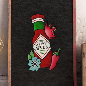 May include: A framed rectangular wall art print featuring a black background with a central illustration of a red hot sauce bottle. The bottle label displays the text STAY SPICY. A light blue flower and a red chili pepper are positioned below.