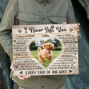 May include: A wooden sign with a heart-shaped cutout featuring a photo of a small, light brown dog. The sign has a woodgrain background and the text "I Never Left You" with the name "Cubby" and a message about an unbreakable bond and love that lasts forever.