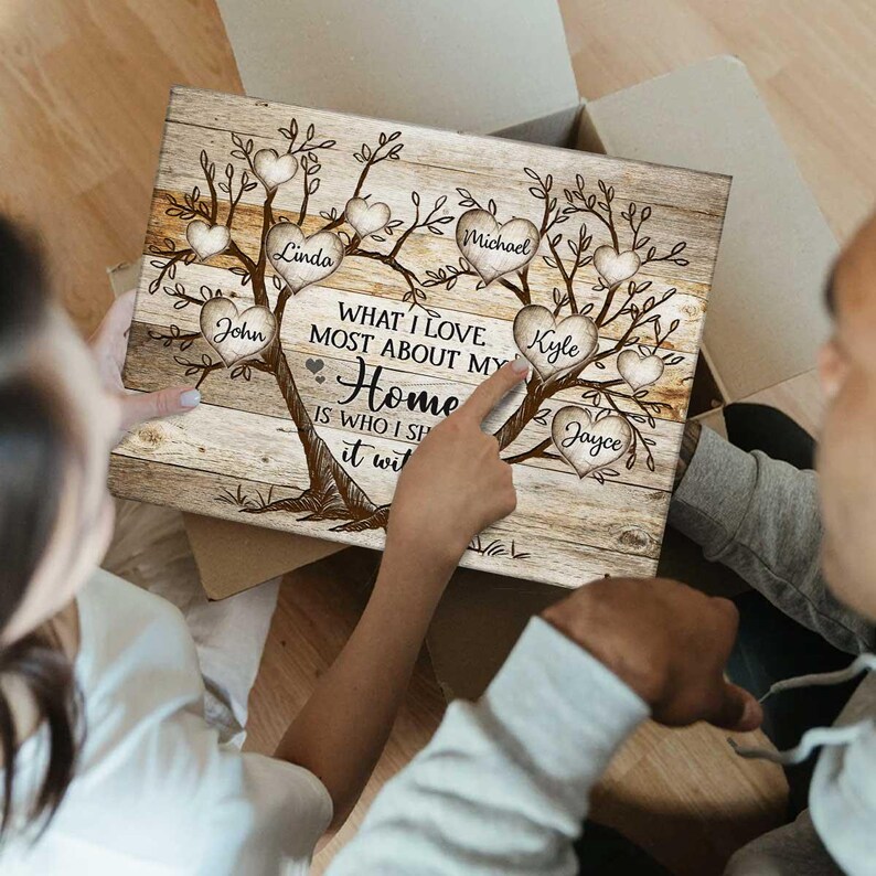 May include: A wooden sign featuring a family tree design. The tree has branches with hearts that have names written on them, including Linda, John, Michael, Kyle, and Jayce. The text on the sign reads "What I love most about my home is who I share it with."