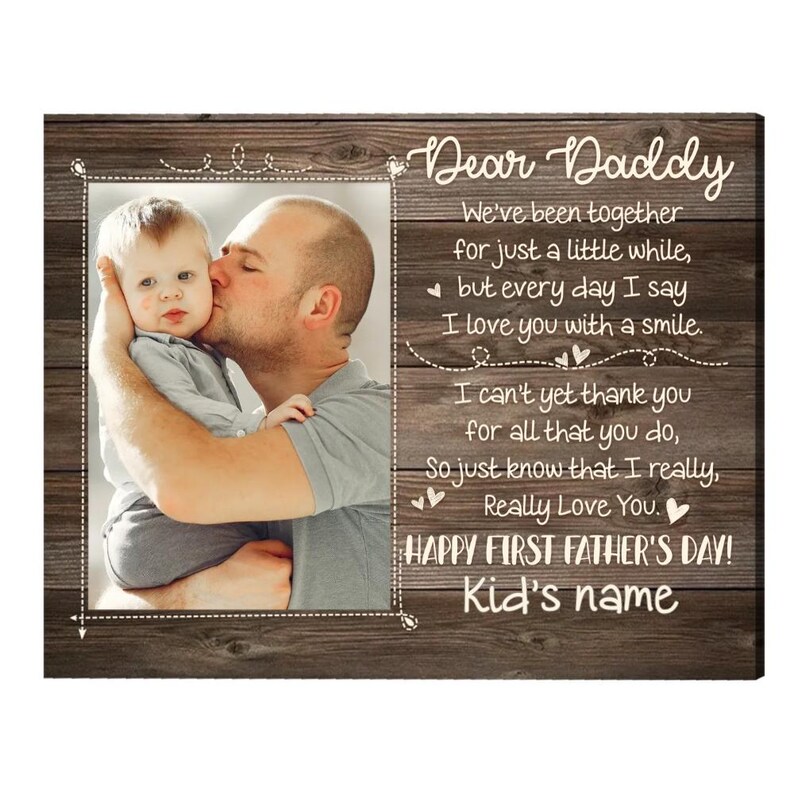 Puede incluir: Foto enmarcada en madera con una imagen de un padre besando a un beb&eacute;. El texto dice "Querido Pap&aacute;" e incluye un mensaje del D&iacute;a del Padre. El marco tiene un aspecto r&uacute;stico de vetas de madera.