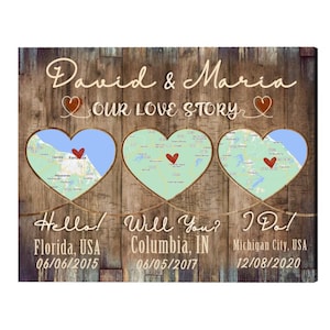 May include: Wooden wall art with a rustic design. The artwork features three heart-shaped cutouts with map details, and the names "David & Maria" above. Text includes "Our Love Story," and dates and locations.