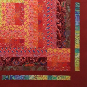 May include: A close-up of a colorful quilt with a red, orange, yellow, and blue pattern. The quilt is made of different fabrics and has a patchwork design.