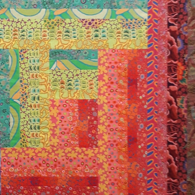 May include: A colorful quilt with a geometric pattern made from various fabrics with different textures and patterns. The quilt is made up of squares and rectangles in shades of red, orange, yellow, green, and blue.