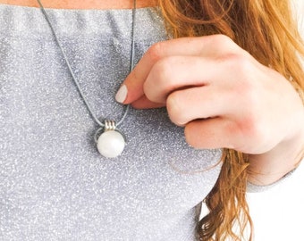 Silver breastfeeding fiddle necklace with pearl detail, perfect for babywearing and nursing.