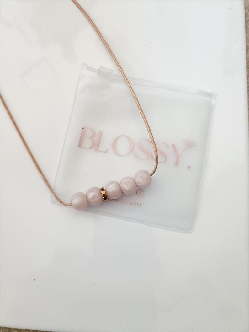 Pink pearl silicone necklace of five small beads separated with a rose gold spacer bead, necklace placed in giftbox.