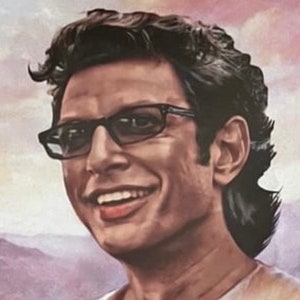 May include: A portrait of a smiling person wearing black-framed glasses. The person has dark hair and is wearing a light-colored shirt. The background features a soft, blurred landscape with shades of purple and pink.