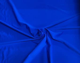 May include: A close-up of a bright blue fabric with a smooth texture. The fabric is folded and draped, creating soft folds and curves.