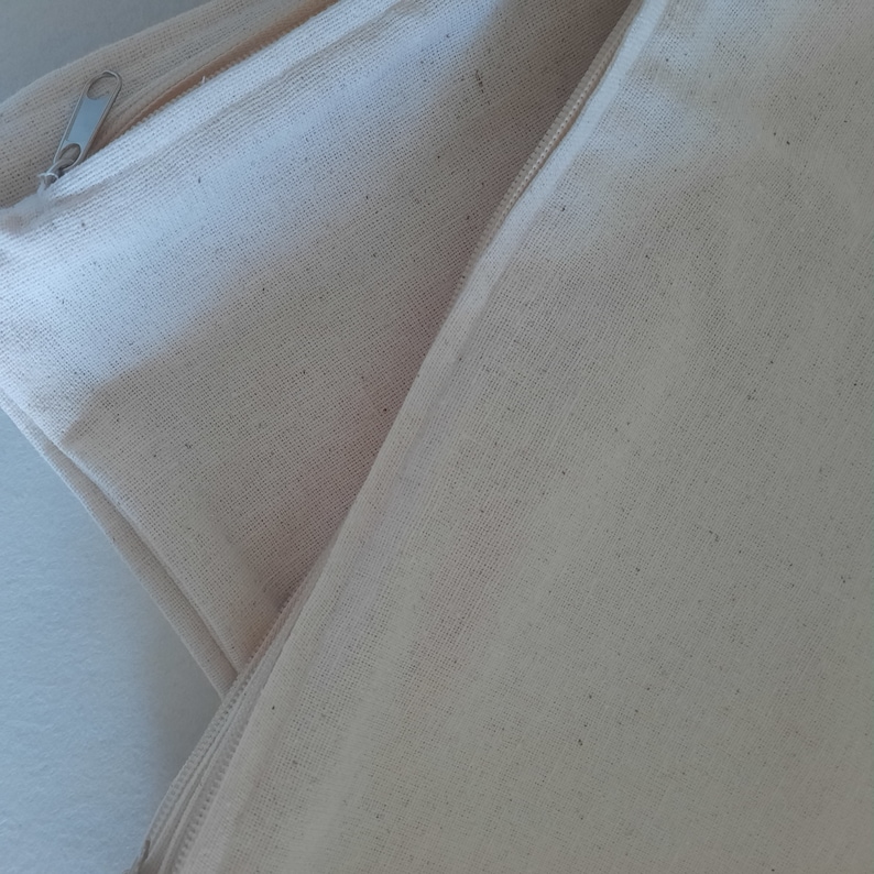 May include: Two off-white canvas pouches with a zipper closure. The pouches are folded over each other, showing the zipper on the top pouch.