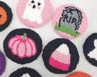 May include: Nine colorful felt circles with various Halloween-themed designs, including a ghost, a pumpkin, a candy corn, a tombstone, and a skull. The circles are all approximately 3 inches in diameter and are made with a variety of colors, including pink, black, white, green, and orange.