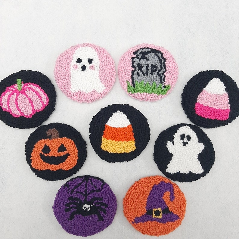 May include: Nine colourful felt ornaments with Halloween themes. The ornaments feature a ghost, a pumpkin, a candy corn, a tombstone, a spider, a witch's hat, a lollipop, a ghost, and a jack-o-lantern.