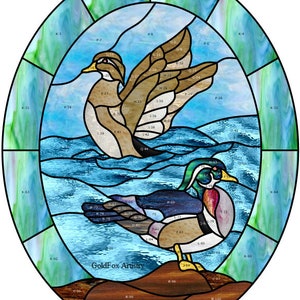 Może przedstawiać: Wzór witrażu przedstawiający dwie kaczki, jedną brązową, a drugą zielono-niebieską, pływające w niebiesko-białej scenerii wodnej. Wzór jest oznaczony numerami i literami.