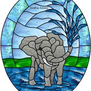Może przedstawiać: Projekt witrażu przedstawiający szarego słonia stojącego w niebieskim zbiorniku wodnym. Słoń ma długi trąbę i duże uszy. Tło to niebieskie niebo z białymi chmurami i zieloną trawą. Tekst "GoldFox Artistry" jest widoczny w górnej części środkowej obrazu.
