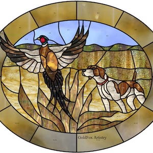 May include: A stained glass window design featuring a pheasant in flight and a hunting dog, set against a background of tall grass and a blue sky. The design is framed by a gold oval border with the text "GoldFox Artistry" at the bottom.