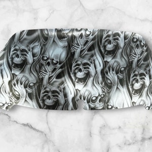 May include: A motorcycle fairing featuring a detailed, airbrushed design of screaming skulls in shades of gray and white. The skulls have exaggerated expressions and are surrounded by a smoky, ethereal effect, creating a gothic aesthetic.