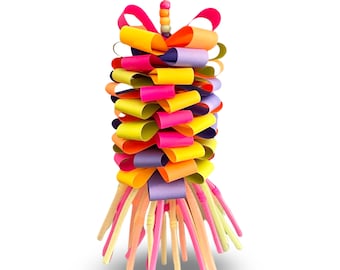 May include: A colorful paper streamer with a multi-colored bow at the top. The streamer is made of strips of paper in yellow, pink, purple, and green. The streamer is hanging from a string.