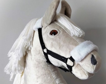 May include: A white plush rocking horse head with a black halter. The horse has a white mane and tail.