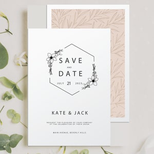 May include: A white save the date card with a black hexagonal frame with floral accents. The text reads "Save the Date" with the date "July 21, 2023". Below the date, it reads "Kate & Jack" and includes the text "Request the pleasure of your company at the celebration of their union. Main Avenue, Beverly Hills."