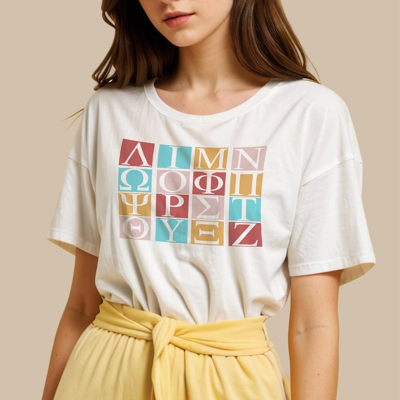 May include: White t-shirt with a graphic of the Greek alphabet in colorful squares. The letters are in white and the squares are in pink, blue, yellow, and red.
