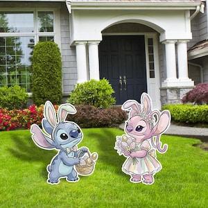 May include: Two cartoon character yard decorations, one blue and one pink, each wearing bunny ears. The blue character holds a basket of eggs, and the pink character holds a bouquet of flowers. They are standing on a green lawn in front of a house.