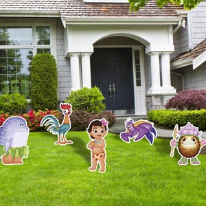 May include: A collection of colorful character cutouts, including a shark, rooster, girl, crab, and coconut, are displayed on a green lawn in front of a house. The cutouts are designed with cartoon-like features and vibrant colors.