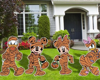 Puede incluir: Cinco personajes de dibujos animados vestidos de momias para Halloween. Los personajes son Mickey Mouse, Minnie Mouse, Donald Duck, Daisy Duck y Goofy. Todos están de pie en un césped verde frente a una casa.