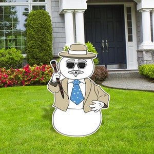 May include: A cartoon snowman wearing a tan suit, a blue tie with white stars, sunglasses, and a brown fedora. The snowman is holding a brown and black walking stick.