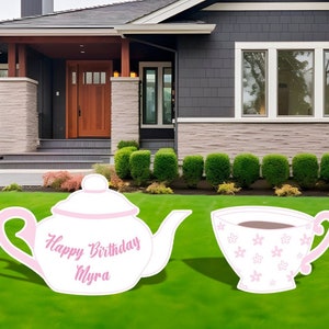 May include: Pink and white teacup and teapot yard sign with the text "Happy Birthday Myra".