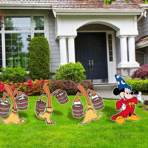 May include: Outdoor yard decorations featuring Mickey Mouse in a sorcerer's outfit and several broom figures carrying buckets. The figures are set on a green lawn in front of a house with a white porch and dark blue door.