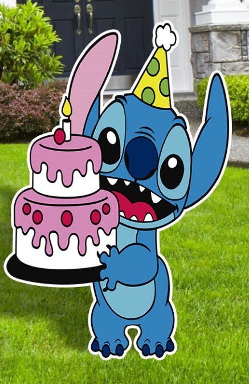 Op de afbeelding: Een blauw cartoonfiguur met een roze oor en een groen-gele feestmuts houdt een roze en witte gelaagde taart vast met een brandende kaars erop.