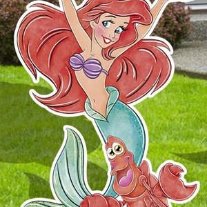 Puede incluir: Ariel, la Sirenita, con cabello rojo y un sujetador de concha p&uacute;rpura, se muestra con su amigo el cangrejo Sebasti&aacute;n. Ariel sonr&iacute;e y tiene los brazos levantados. Sebasti&aacute;n es rojo y tiene ojos grandes y redondos.