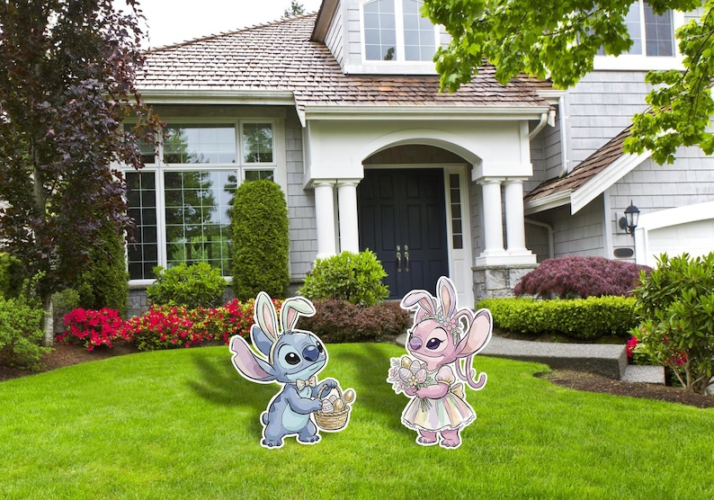 May include: Two cartoon character yard decorations, one blue and one pink, each wearing bunny ears. The blue character holds a basket of eggs, and the pink character holds a bouquet of flowers. They are standing on a green lawn in front of a house.