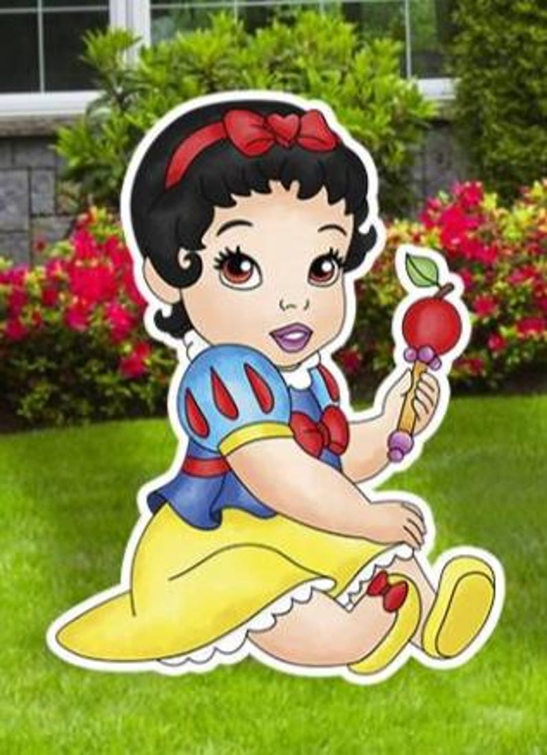 May include: A cartoon illustration of a baby character with black hair, a red headband with a bow, and a blue and yellow dress. The character is sitting down and holding a red apple-shaped rattle with a green leaf on a light brown handle.