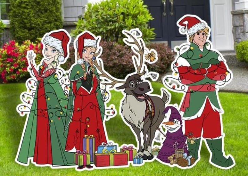 以下が含まれることがあります： お祝いの衣装を着た漫画のキャラクターが特徴のクリスマスの庭の装飾。このセットには、2人のプリンセス、トナカイ、雪だるま、男性のフィギュアが含まれており、すべて休日のライトとサンタの帽子で飾られています。カラフルなギフトボックスも含まれています。