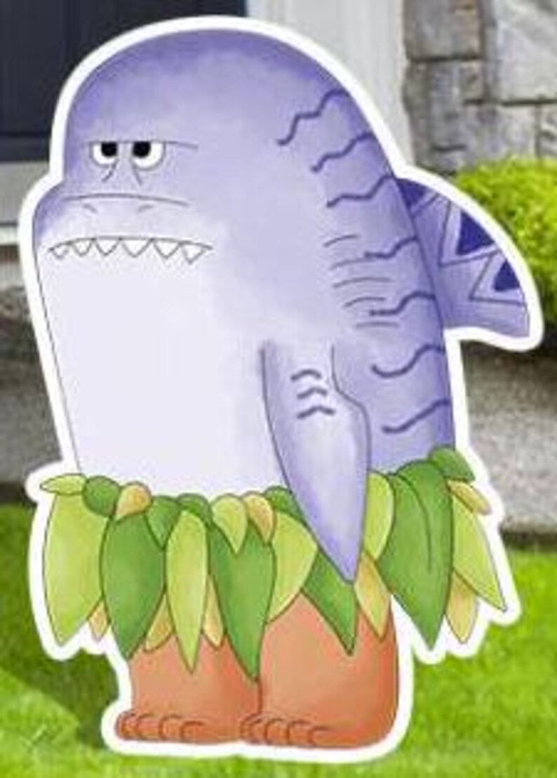 May include: A cartoon shark character with a grumpy expression. The shark is primarily light purple with darker purple stripes and a tribal design on its fin. It wears a grass skirt and has orange feet. The image is a yard decoration.