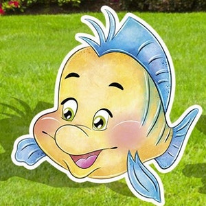 Puede incluir: Un pez de dibujos animados amarillo y azul con una gran sonrisa y ojos grandes. El pez tiene una aleta azul en la cabeza y una aleta caudal azul.