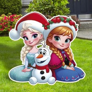 Puede incluir: Decoraci&oacute;n de jard&iacute;n colorida con Elsa, Anna y Olaf de la pel&iacute;cula Frozen. Elsa lleva un gorro de Pap&aacute; Noel, mientras que Anna tiene una corona de acebo. Olaf es un mu&ntilde;eco de nieve con una bufanda roja. Los personajes est&aacute;n sobre c&eacute;sped verde.
