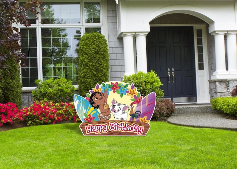 May include: A colorful cardboard cutout featuring characters from the animated movie Moana. The cutout includes a young Moana, a pig, and a rooster. The cutout is decorated with flowers, surfboards, and the text "Happy Birthday".